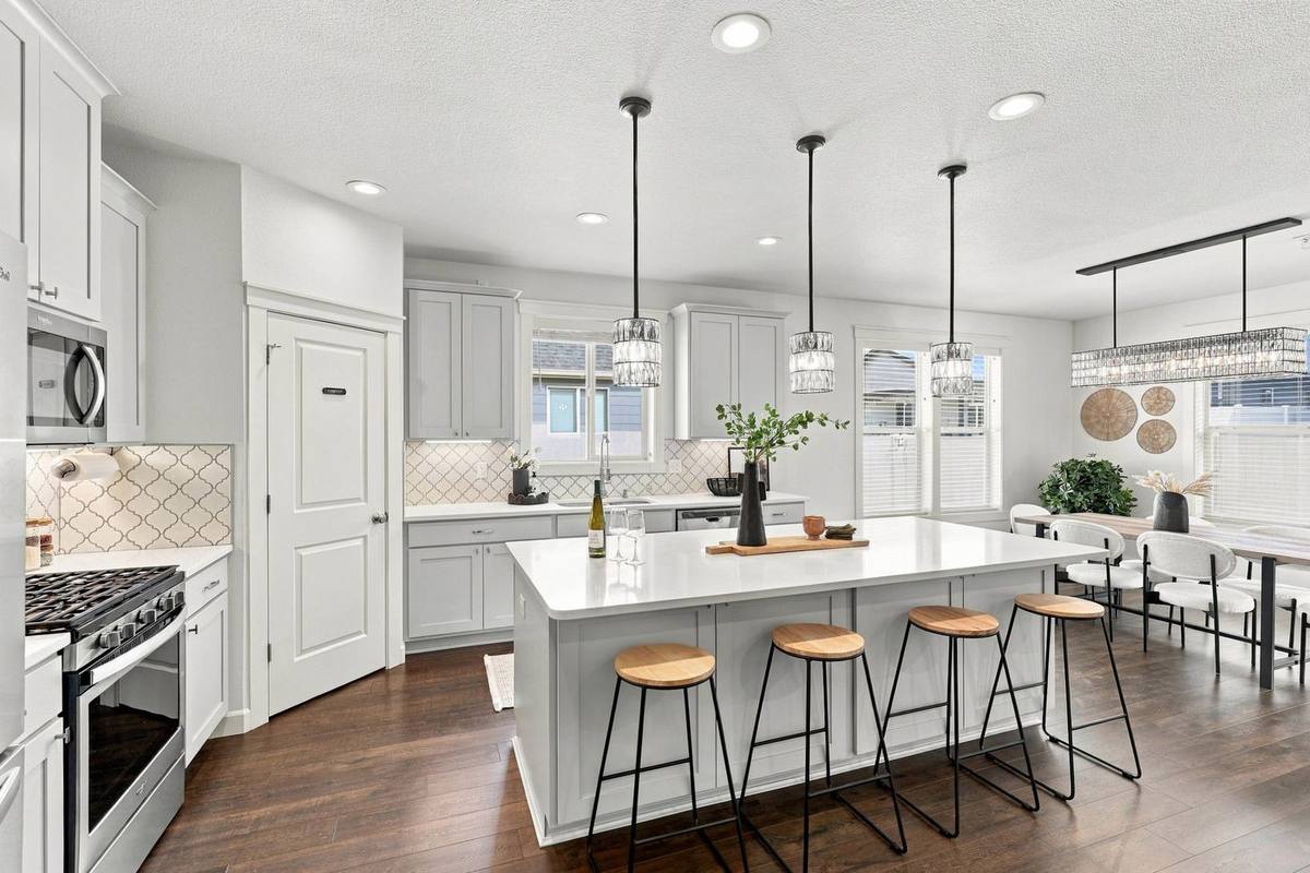 White kitchen with quartz island and pendant lights